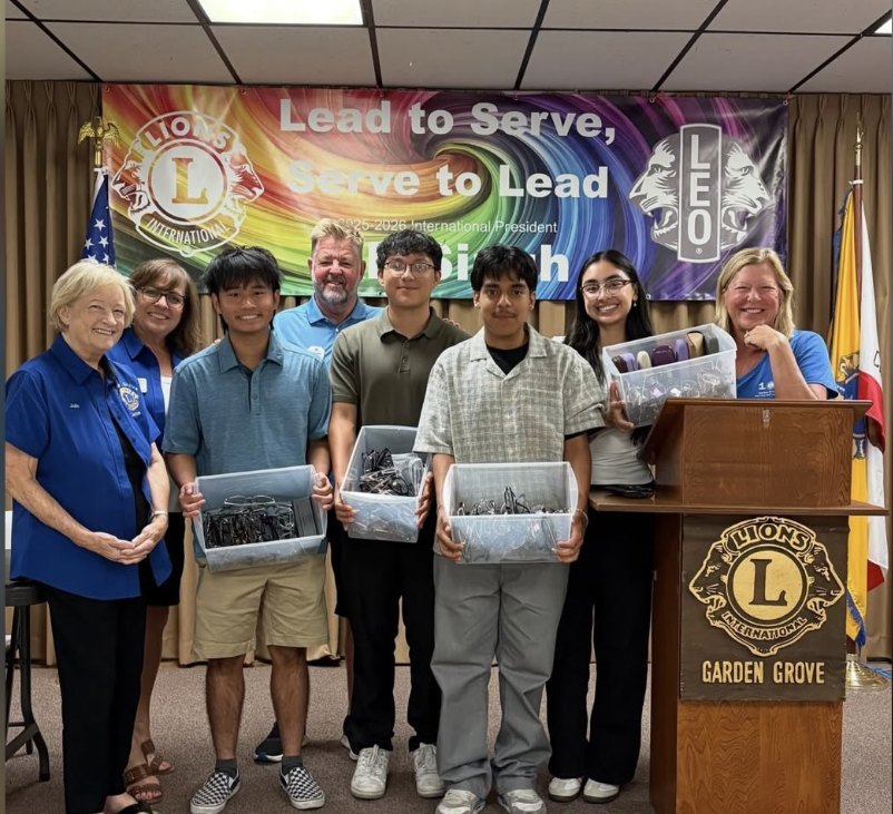 The NeuOptics team with Garden Grove Lions Club members, holding bins of donated glasses