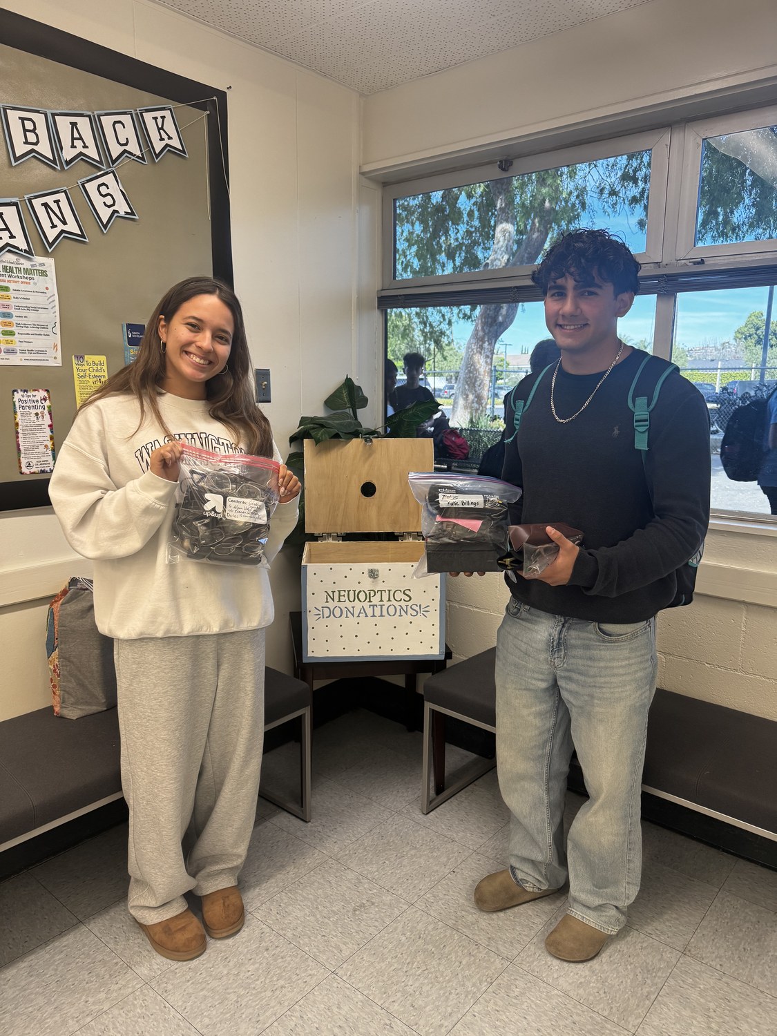 NeuOptics students Yamin and Gaby collecting donated glasses at Villa Park High School
